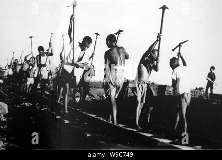 --FILE--Young Chinese workers pave rails of the Chengyu (Chengdu-Chongqing) Railway in southwest Chinas Sichuan province, 1951. Stock Photo