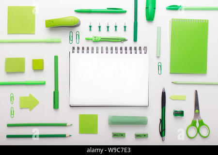 Flat lay of green colored office supplies with copy space on white Stock Photo