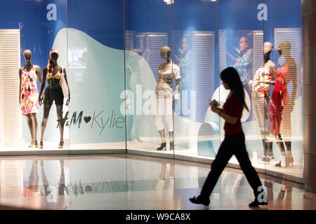 --FILE--A young Chinese woman walks past an H&M (Hennes & Mauritz) store in Shanghai, China, 22 May 2007.   Swedish fashion giant Hennes & Mauritz (H& Stock Photo