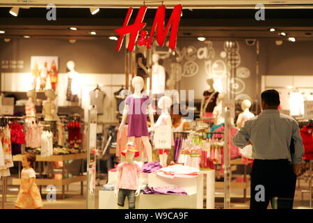 FILE A man stands at an H M boutique in a shopping mall in Shanghai China 22 May 2007. Swedish clothing retailer Hennes Mauritz H M plans t Stock Photo Alamy