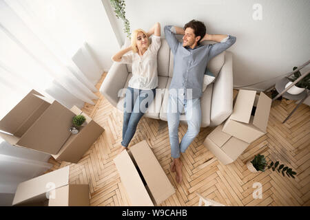Lovely Couple Relaxing On Sofa In New Flat, Above View Stock Photo