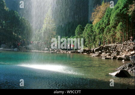 Tourists look at a waterfall in the Yandang Mountain senic spot in Wenzhou city, east Chinas Zhejiang province. Stock Photo