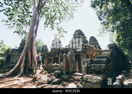 Caucasian blonde woman discovering the ruins of Angkor Wat temple complex in Siem Reap, Cambodia. Stock Photo