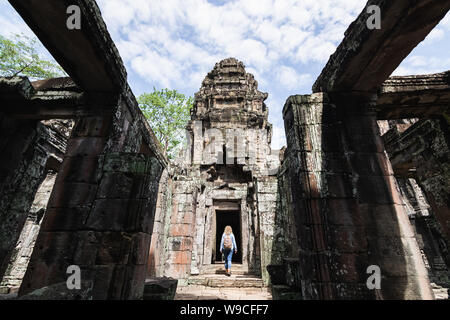 Caucasian blonde woman discovering the ruins of Angkor Wat temple complex in Siem Reap, Cambodia. Stock Photo