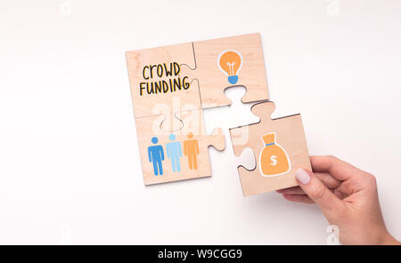 Woman connecting the last puzzle with money for idea Stock Photo