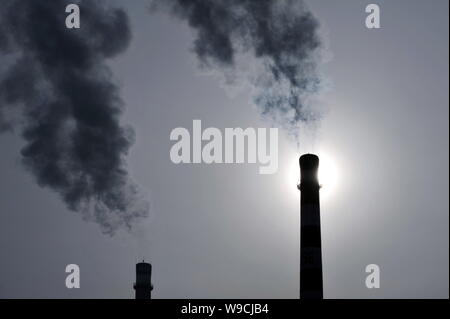 --FILE--Smoke is seen emitted from chimneys of a heat power plant in Daqing city, northeast Chinas Heilongjiang province, 15 March 2009.   China will Stock Photo