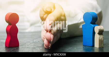 The hand separates the father with the child from the mother. The decision of the court who will become the guardian of the child. The process of divo Stock Photo