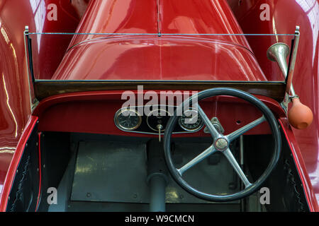 The detailed view of vintage car with driving wheel. The red classic veteran car. Stock Photo