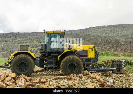 wheeled bulldozer on the construction of roads in the mountains Stock Photo