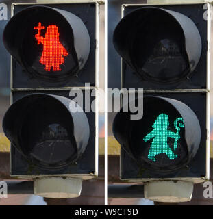 Fulda, Germany. 13th Aug, 2019. The picture combo shows a traffic light on the left, where a red Bonifatius with a warning cross asks the pedestrian to stop. On the right a green Bonifatius, who points out with a shepherd's staff that crossing the road is allowed. The East Hessian bishop's town has mounted traffic light men in the shape of St. Boniface at a first intersection. Credit: Jörn Perske/dpa/Alamy Live News Stock Photo