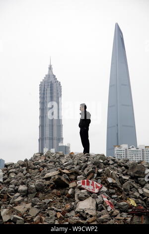 A Chinese man stands on the rubble of old houses dismantled for the construction of new real estate projects near the Bund in Huangpu District as Jinm Stock Photo