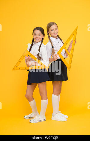 School knowledge. Explore world with math. Discover mathematics patterns. Mathematical theory combining algebraic and geometric methods. School students study geometry. Pupil school girls big rulers. Stock Photo