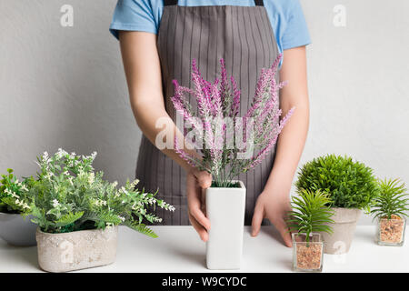 Designer in apron putting lavender plant on table Stock Photo