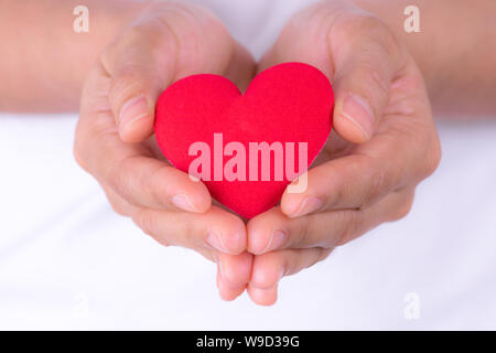 Woman hands holding red heart for world heart day or world health day concept. Stock Photo