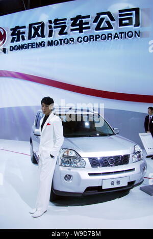 --FILE--A model poses next to a Nissan X-Trail, manufactured by Dongfeng Nissan, a joint venture between Nissan and Dongfeng Motor Corporation, at the Stock Photo