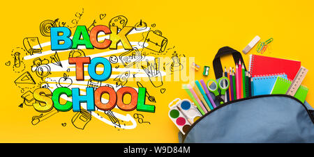 Backpack with stationery inside on yellow background Stock Photo