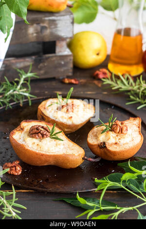 Baked pears with ricotta, walnuts and honey. Light healthy dessert without sugar. A warming dish. Stock Photo