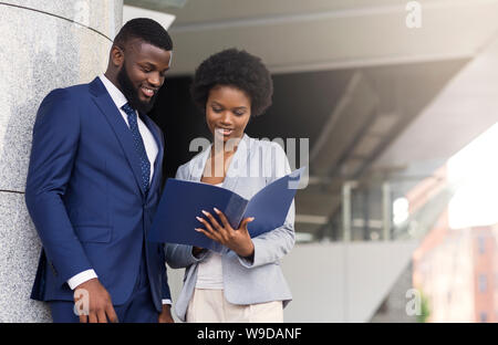 Successful business partners checking financial reports outdoors Stock Photo
