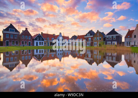 Traditional Dutch houses with a canal and a beautiful sunset with reflections in the water - Travel image - The Netherlands - Travel image Stock Photo
