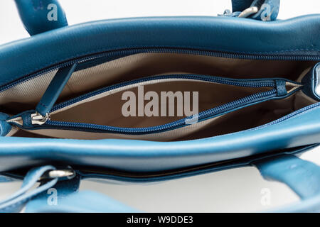 Top down view looking into an open zipped inner pocket compartment inside an empty handbag purse from above. Stock Photo