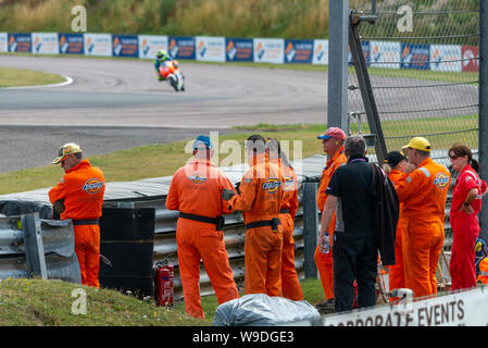 race marshalls trackside at Thruxton BSB motorcycle race. Stock Photo