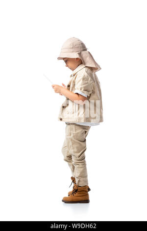 side view of explorer child in glasses and hat using digital tablet isolated on white Stock Photo