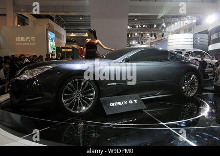 Visitors look at a model posing with a Geely GT concept roadster during the Auto China 2008 car show in Beijing, China, 20 April 2008.   The Auto Chin Stock Photo