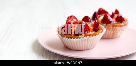 Strawberry vanilla cream cheese tarts on a pink plate, side view. Copy space. Stock Photo