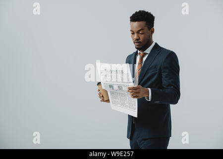 handsome bearded african american man reading business newspaper isolated on grey Stock Photo