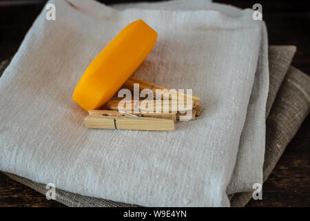 Stack of clean linen towels, clothespins and natural soap on table. Stock Photo