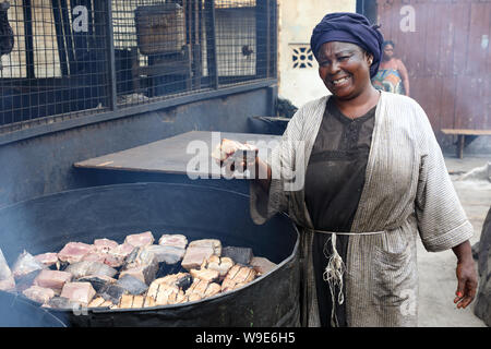 Market woman sells smoked fish in the fishing village Jamestown in Accra, Ghana Stock Photo