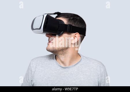 Young man using vr headset in studio, experiencing virtual reality Stock Photo