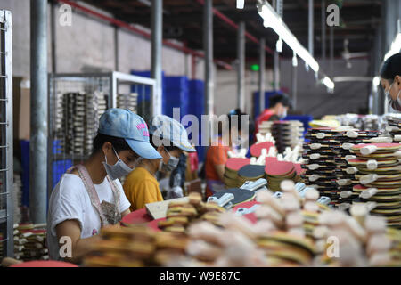 Xingye, China's Guangxi Zhuang Autonomous Region. 13th Aug, 2019. Staff members make table tennis bats at a plant in Xingye County, south China's Guangxi Zhuang Autonomous Region, Aug. 13, 2019. In recent years, by developing plants and exploring various ways to creat job opportunities, Xingye County has gained fruits in poverty alleviation. Credit: Cao Yiming/Xinhua/Alamy Live News Stock Photo