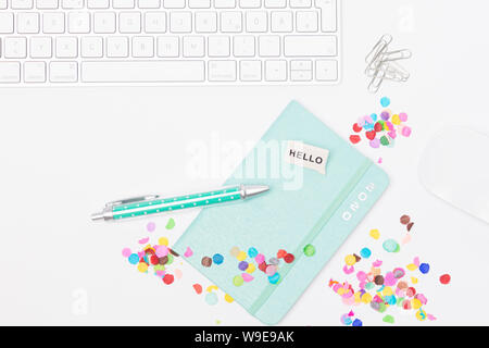 Desk with colorful confetti, keyboard and mouse, calendar 2020 and a ballpoint pen Stock Photo