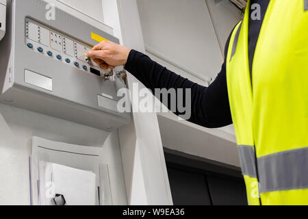 Electrician Opening Fire Panel In Server Room Stock Photo