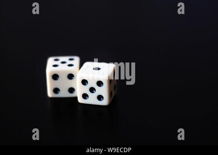 Two white dice on a black background. Stock Photo
