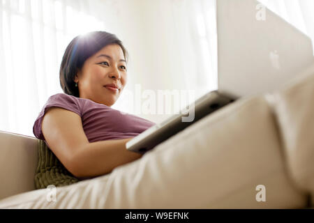 Happy young woman using a laptop computer. Stock Photo