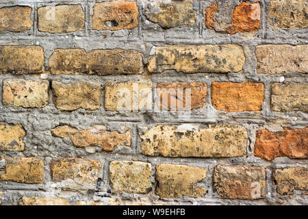 Weathered ancient red brick wall, antique medieval castle brick wall architecture orange brown decorative plaster aging medieval old bricks material Stock Photo