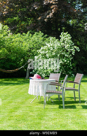 The table with chairs in the spring garden Stock Photo