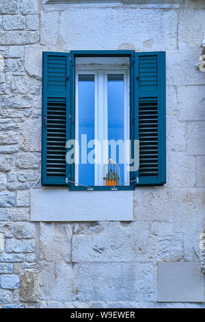 Blue window in a stone wall Stock Photo