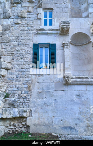 Blue window in a stone wall Stock Photo