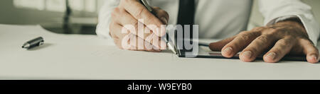 Wide view image of an architect working on a project drawing using a ruler and pencil. Stock Photo