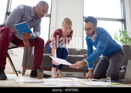 Multi-ethnic team of creative millenials collaborating on a brainstorm project Stock Photo