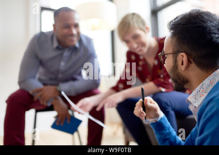 Multi-ethnic team of creative millenials collaborating on a brainstorm project Stock Photo