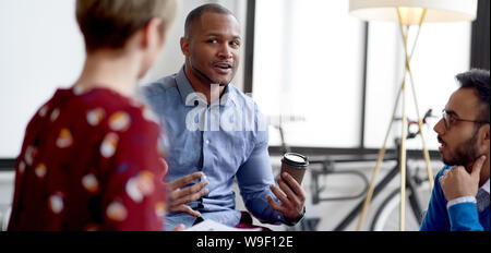 African American businessman leading a team of creative millenials collaborating on a brainstorm project Stock Photo