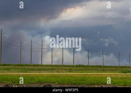 Approaching storms and a brush fire in the Northern Everglades. Stock Photo