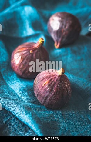 Three fresh figs on the blue linen napkin Stock Photo