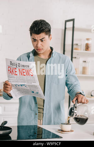 shocked asian man reading fake news newspaper while pouring coffee in ...