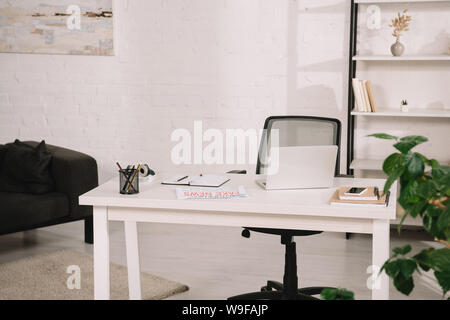spacious, light living room with white brick wall, table and rack Stock Photo