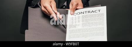cropped view of african american businessman showing contract on dark background, panoramic shot Stock Photo